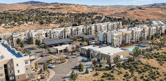 A large residential complex with a swimming pool and a parking lot.