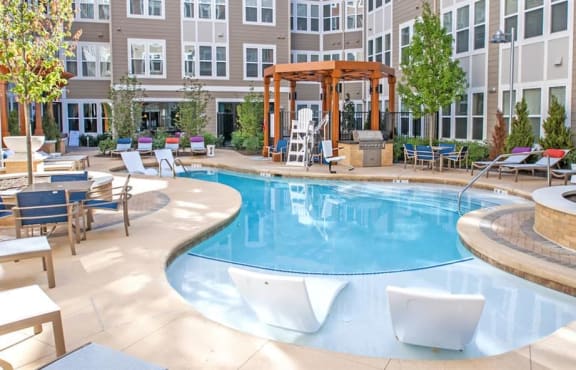 a swimming pool in a courtyard with an apartment building in the background