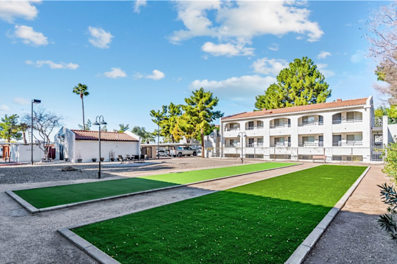A sunny day at a park with a building in the background.