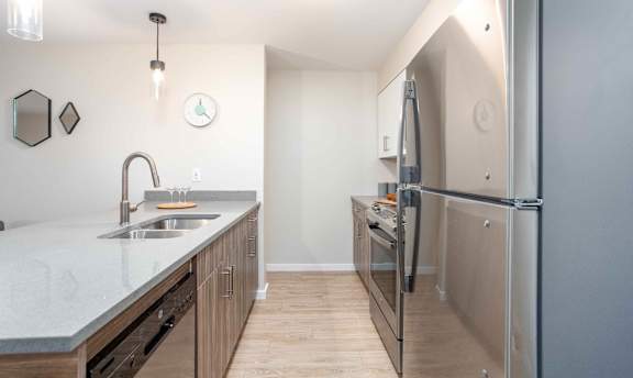 A kitchen with a sink, refrigerator, and cabinets. at G17 Apartments at Tamarack, Edmonton