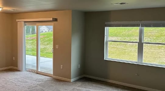 an empty living room with a sliding glass door