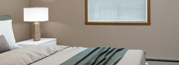 A bedroom with a large bed and a painting on the wall.