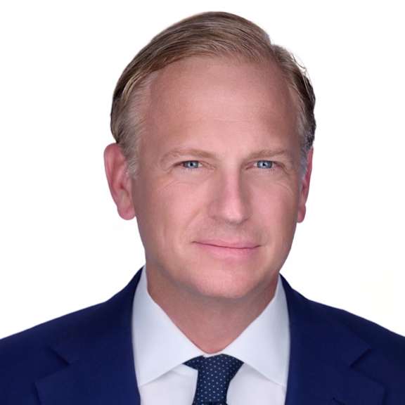 a man wearing a suit and tie and smiling