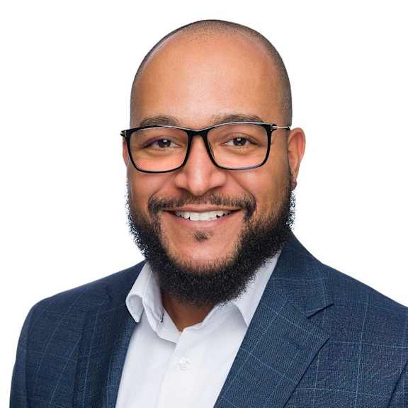 a man in a suit and glasses smiling