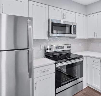 a kitchen with white cabinets and stainless steel appliances