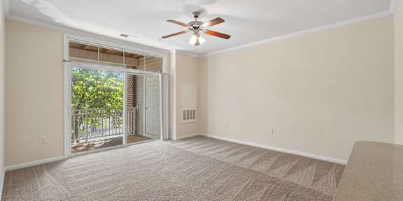 a living room with white couches and rattan chairs