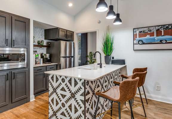 a kitchen with a large center island with a sink and two stools