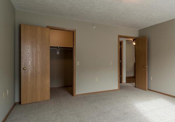 A bedroom with a carpeted floor and a ceiling light.