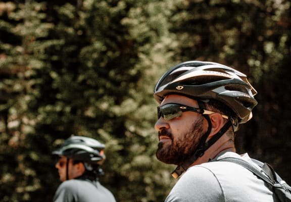 Men Wearing Helmets Riding Bikes Together