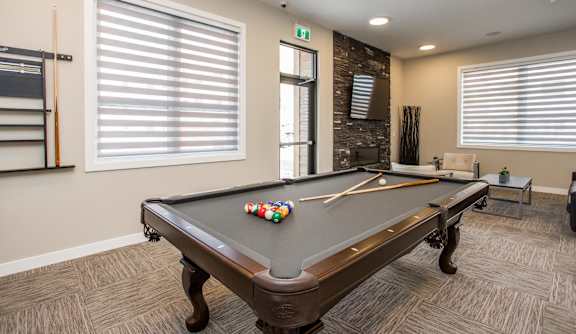 A pool table with a few balls and a cue stick on it.