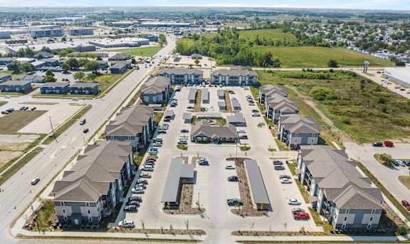 A bird's eye view of a residential area with multiple houses and a parking lot.