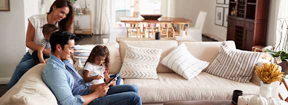 family on a couch looking at a tablet
