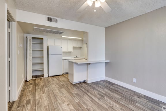 A kitchen area with a white refrigerator and a white countertop.