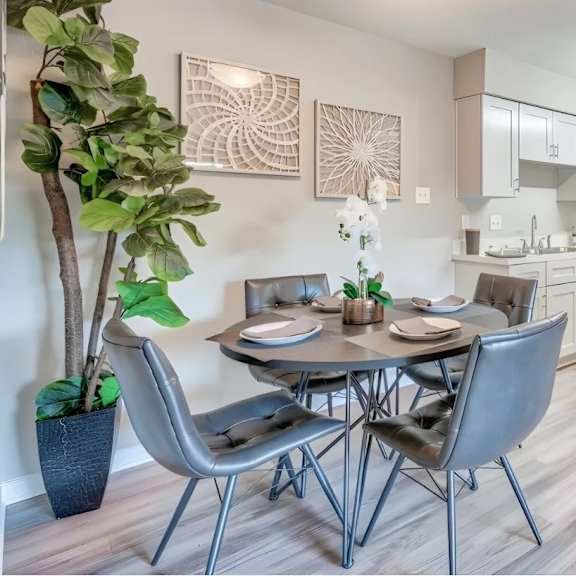 A modern dining room with a table set for four.