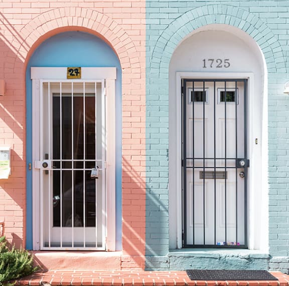 a pink house with a blue door and white archway