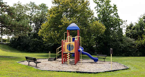 A playground with a blue and yellow structure and a slide at Lawyers Hill Apartments, Elkridge, MD, 21075