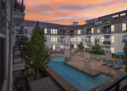 A sunset view of a pool area in a residential building.