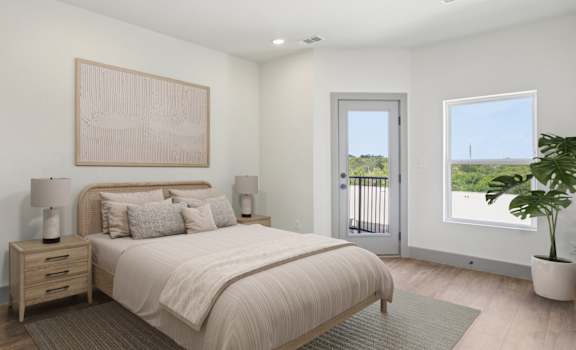A bedroom with a large bed, a nightstand with a lamp, and a painting on the wall.