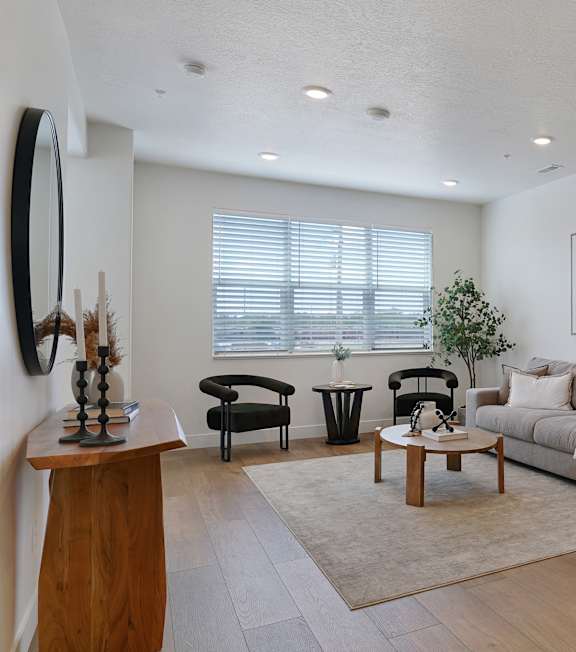 A modern living room with a grey sofa, wooden coffee table, and a television.