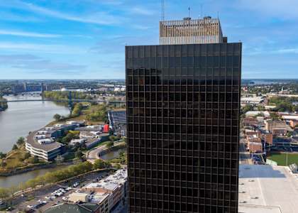 an aerial view of a tall building next to a river