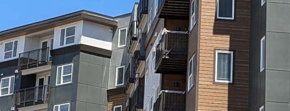 a large apartment building with a blue sky in the background