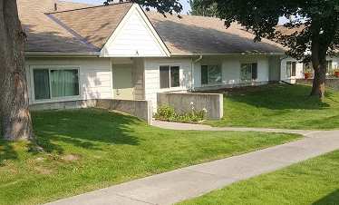 Image of entrance into building and sidewalk with lawn