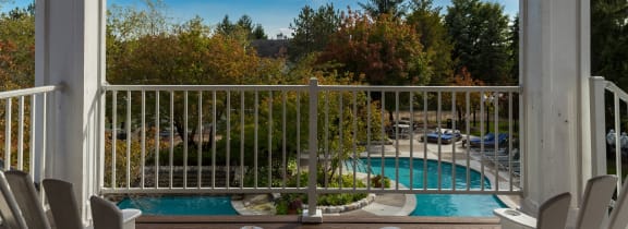a view of a swimming pool from a porch with chairs at Village Club of Farmington Hills, Farmington Hills, MI 48331