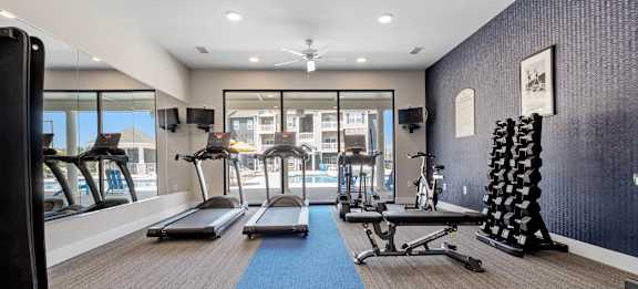 A gym with treadmills, weights, and exercise equipment at Aventura at Wentzville I & II Apartments, Wentzville, Missouri
