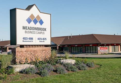 a picture of the meadowbrook business center sign in front of the building