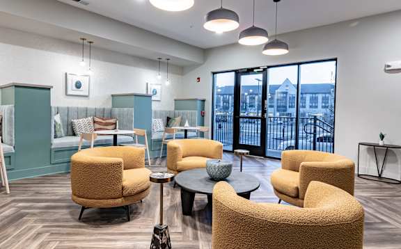 a lounge area with chairs and tables in the lobby of a building