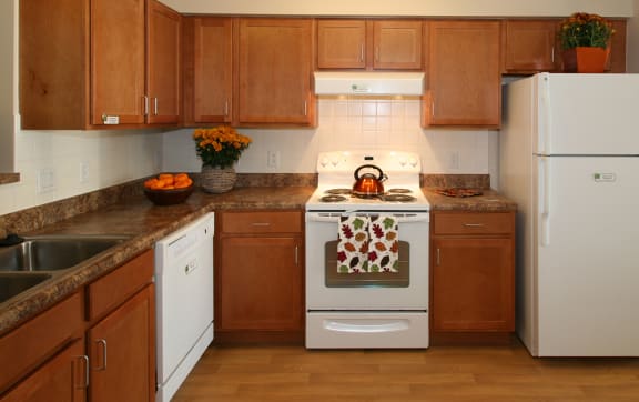 a kitchen with white appliances and wooden cabinets