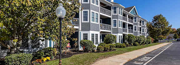 A street view of a residential area with apartment buildings and a sidewalk.