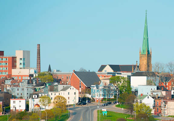 A church with a green steeple is in the background of a town.