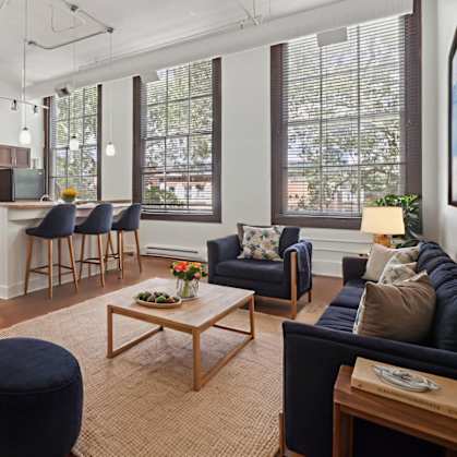 A living room with a blue couch and a wooden coffee table.