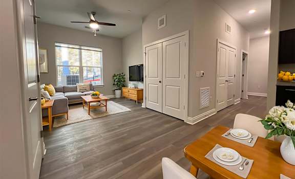 A modern living room with a dining table set for two.