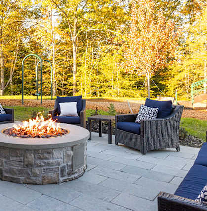 A patio with a fire pit and seating area.