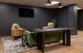 A conference room with a green table and two chairs.