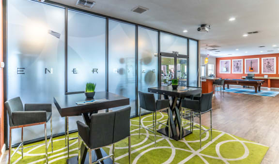 a lobby with tables and chairs and glass walls