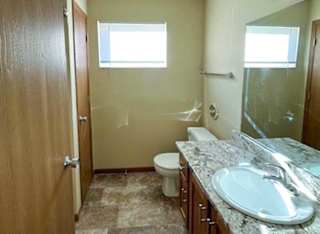 a bathroom with a vanity sink, a mirror, a linen closet, and a window