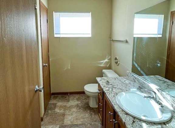 a bathroom with a vanity sink, a mirror, a linen closet, and a window