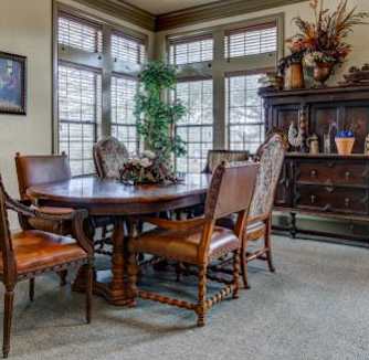 A dining room with a wooden table and chairs.