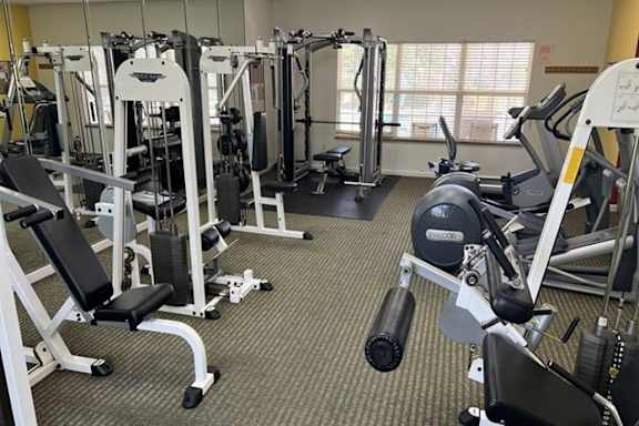 A gym with a variety of equipment including weights and machines.