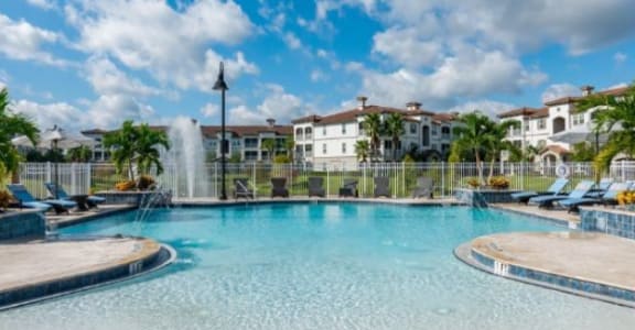 a large pool with chairs and a water fountain
