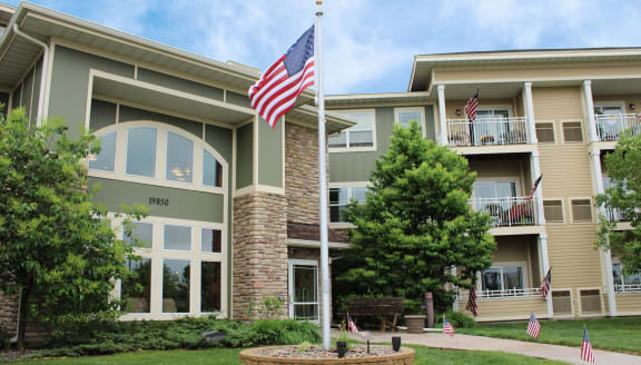 an flag on a pole in front of an apartment building