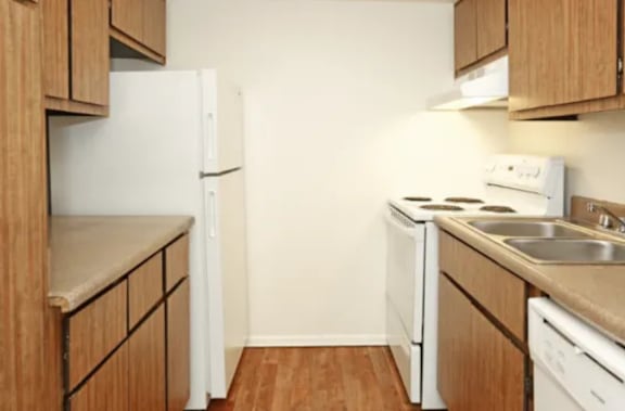 A kitchen with wooden cabinets and white appliances.