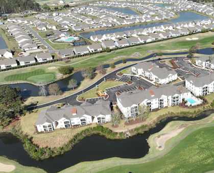A bird's eye view of a residential area with a golf course.