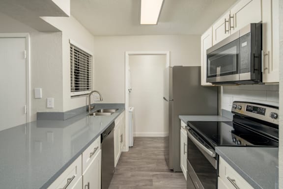A kitchen with a stove, microwave, and oven.