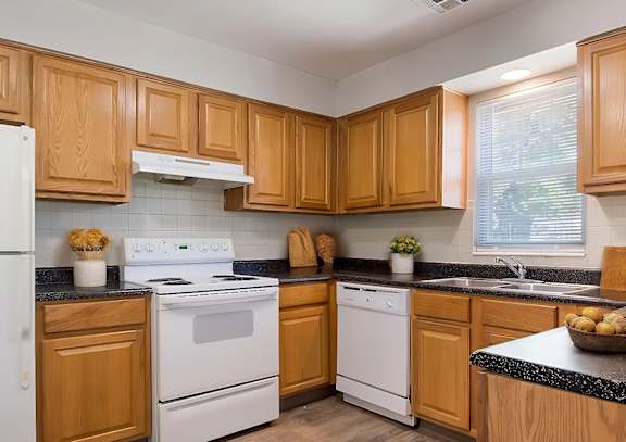 A kitchen with wooden cabinets and white appliances.