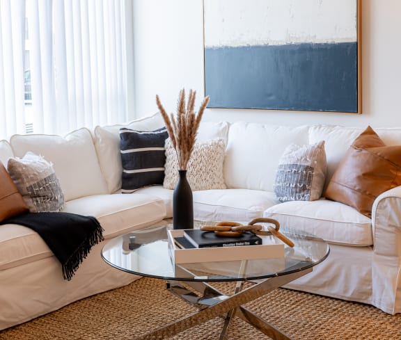 a living room with a white couch and a glass coffee table