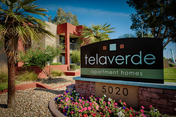 A sign for Telaverde Apartment Homes in front of a building.